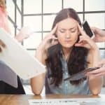 Stressed woman sitting with hands on forehead